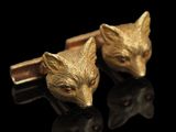 Boutons de manchette représentant une tête de renard dorée sur fond noir avec un reflet