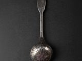 a spoon that is sitting on a black surface