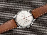 Gros plan sur une montre avec un bracelet en cuir marron