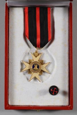 a medal in a red box with a black and red ribbon