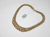 a close up of a gold chain necklace on a white surface