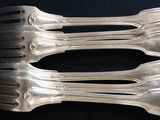 four forks that are sitting on a black table