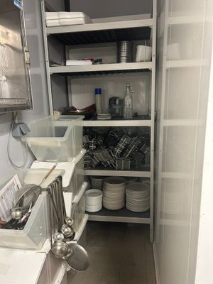 a small kitchen with a lot of dishes on the shelves