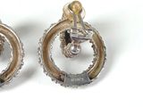 a pair of earrings that are sitting on a white surface