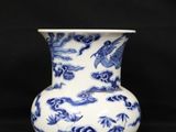 blue and white vase with birds and flowers on it on a black background