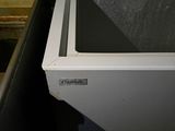underside view of a white chest freezer sitting in a room