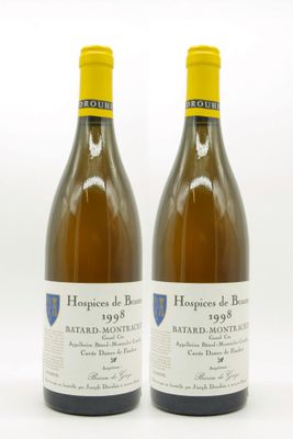 two bottles of white wine sitting next to each other on a white surface