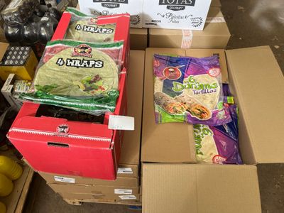 Des cartons de nourriture sont empilés les uns sur les autres dans un entrepôt
