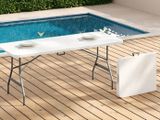une table installée sur une terrasse en bois près d'une piscine