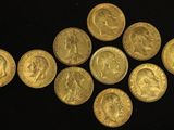 a close up of a bunch of gold coins on a black surface