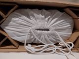 a white bag inside of a cardboard box with a rope
