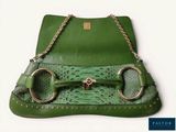 a green purse with two metal rings on it