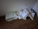 a pile of white bags sitting on the floor next to a wall