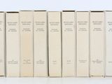 six livres sont alignés sur une surface blanche