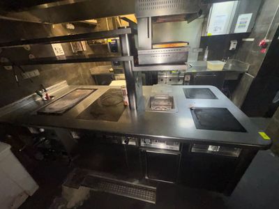 une image d'une cuisine commerciale avec des plans de travail en acier inoxydable