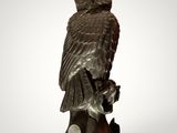une statue de chouette perchée sur une branche d'arbre