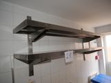 a metal shelf with a sign on it in a bathroom