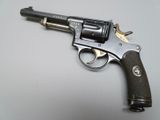 gun on a white surface with a black handle and a brown grip
