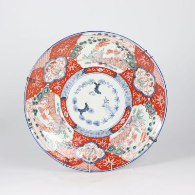 a red and blue plate with a floral design on it
