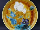 une image représentant une assiette jaune ornée de fleurs bleues et blanches