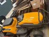 une tondeuse à gazon jaune posée par terre à côté d'un tas de cartons