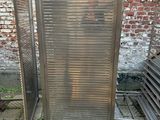 un grillage métallique posé au sol, à côté d'un mur de briques