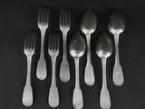 six silver spoons and a fork on a black surface