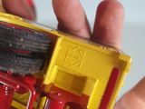 someone is holding a yellow and red toy truck in their hand