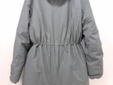 the back of a gray coat hanging on a white wall