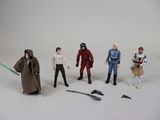 cinq figurines de personnages de Star Wars posées sur une surface blanche