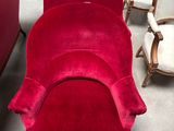 a red chair that is in a room with many chairs