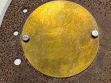 a metal plate with a gold disc on it