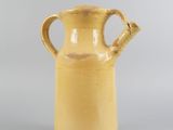 an image of a yellow vase sitting on top of a table