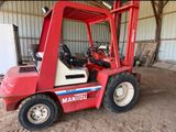 un chariot élévateur rouge garé à l'intérieur d'un bâtiment