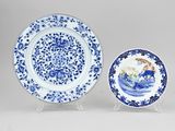two blue and white plates with designs on them sitting on a table