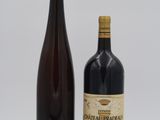 deux bouteilles de vin posées l'une à côté de l'autre sur une surface blanche