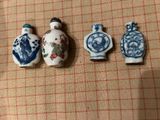 Trois petits vases chinois sont alignés sur une nappe à carreaux.