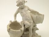 a statue of a boy sitting on a rock with a basket