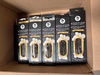plusieurs boîtes de brosses à dents rangées dans un carton posé sur une étagère