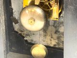 une horloge à laquelle est suspendue une cloche sur le côté