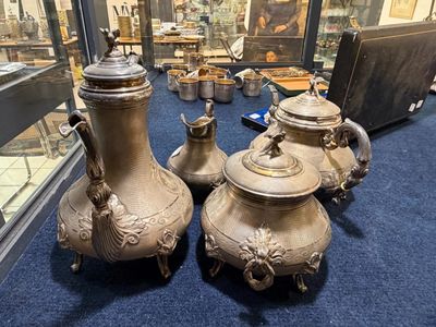 trois vases posés sur un tapis bleu devant une vitrine