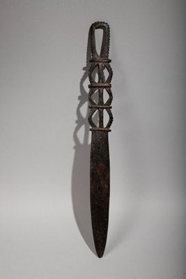 a knife that is hanging on a white wall