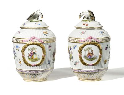 pair of vases with a bird on top of them on a white surface