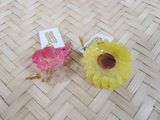 pair of yellow and pink flowers sitting on top of a wooden table