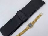 black leather watch case with gold chain and black leather watch band
