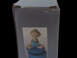 a box with a figurine of a baby sitting on top of it