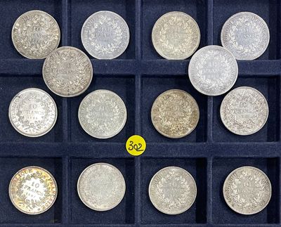 a lot of silver coins in a display case
