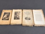 three old books sitting on top of each other on top of a table