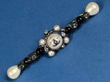 a close up of a black and white bracelet with pearls