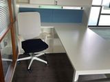 a white desk with a blue chair in the corner of the room